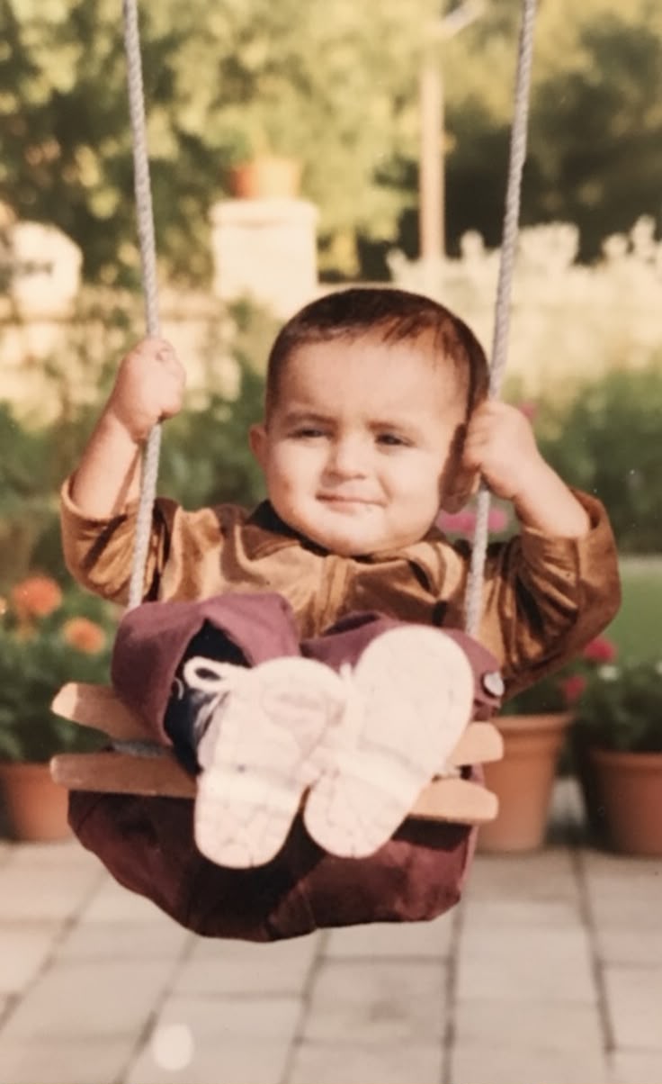 Uzair as a child on a swing